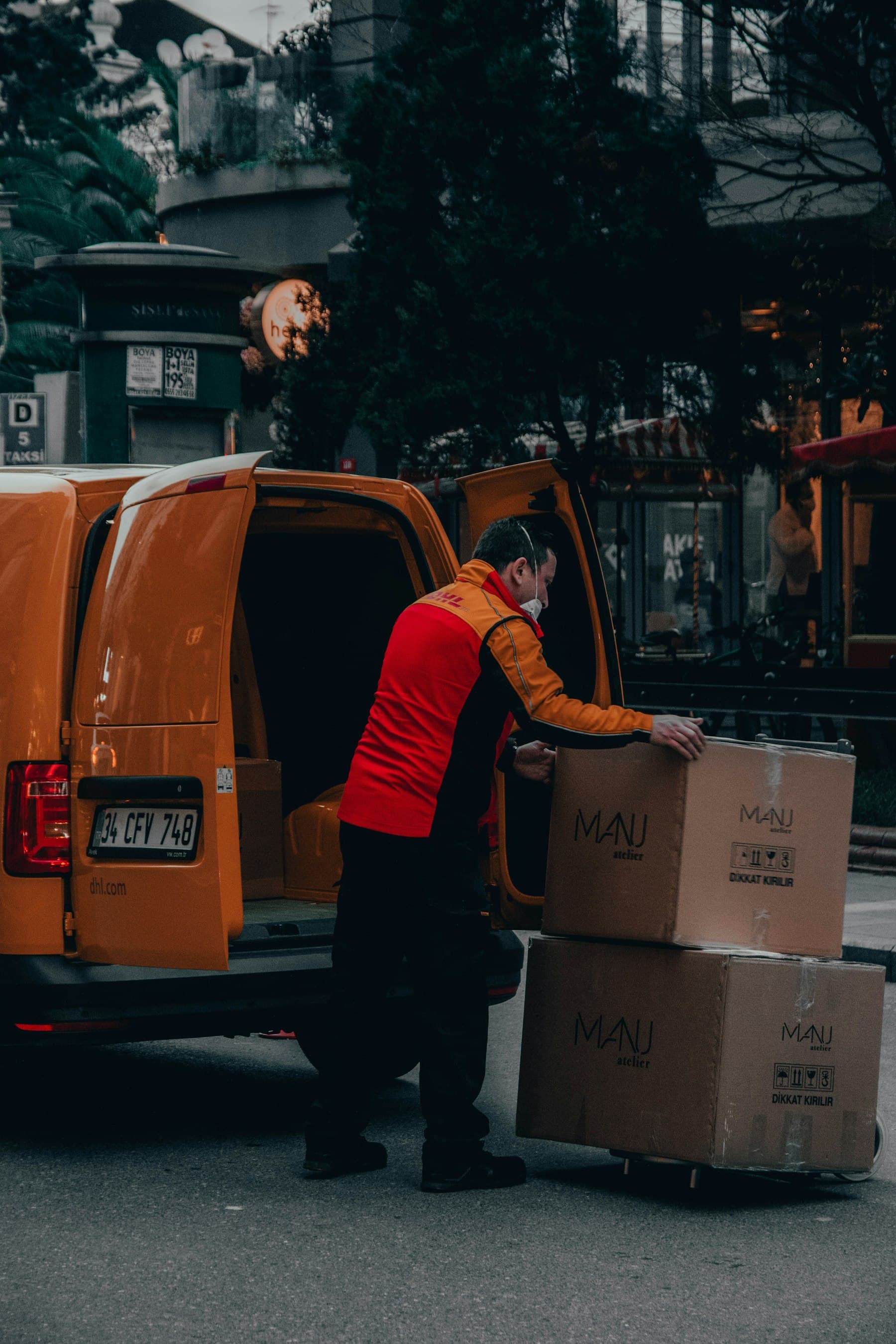 Livreur sortant un carton de sa camionnette